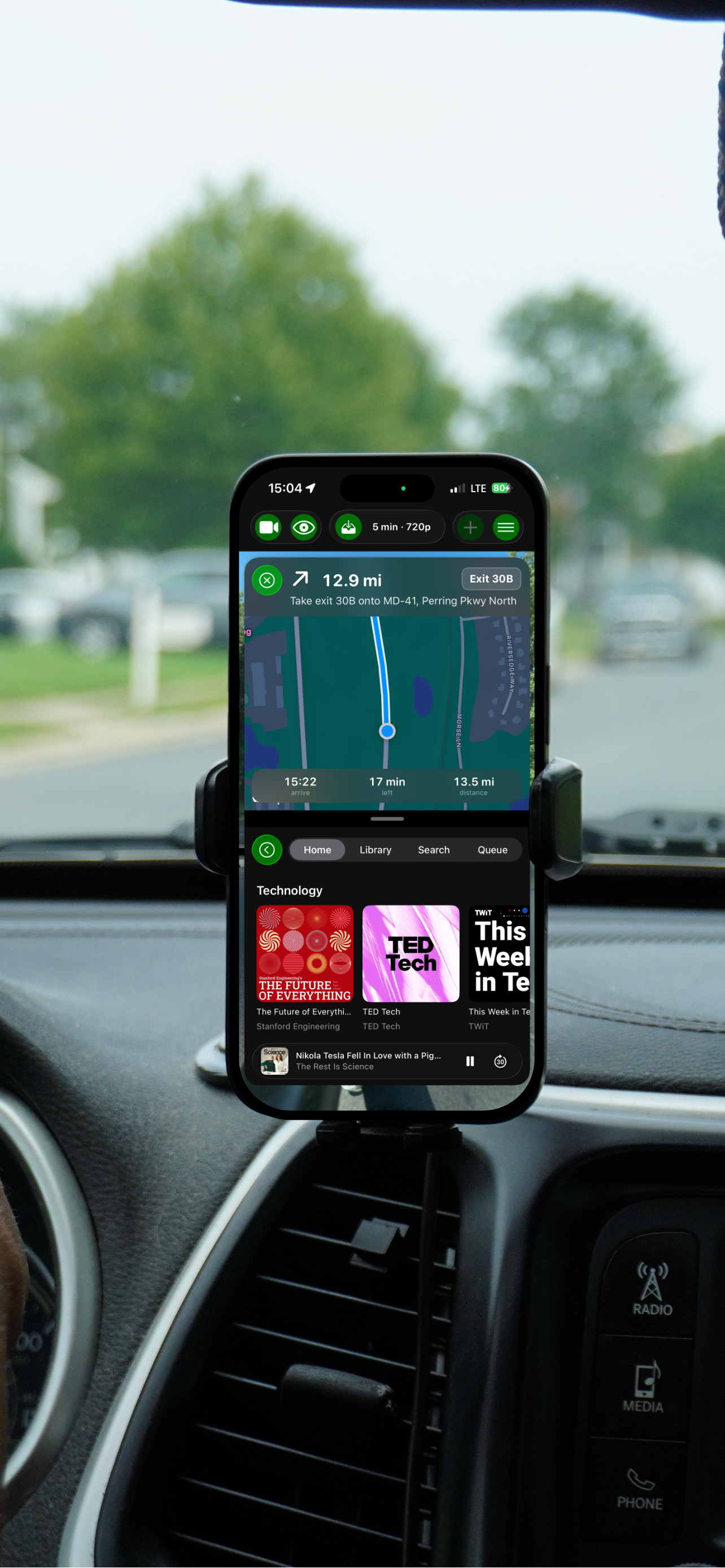 GoDash in a car mount showing turn-by-turn navigation above the Podcasts module browsing technology shows